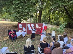 Uczestnicy Narodowego Czytania w plenerze pod lipą.