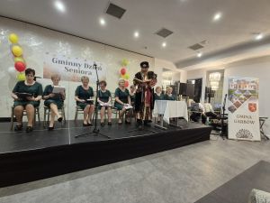 Seniorzy z Koła Rencistów i emerytów w zagrodach biorący udział w Narodowym Czytaniu podczas Gminnego Dnia Seniora