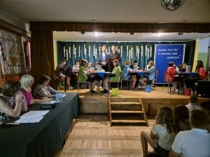 Cztery trzyosobowe zespoły uczniów Szkoły Podstawowej w Bogucinie, jury oraz publiczność podczas Turnieju Wiedzy o Wandzie Chotomskiej.