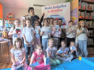 Piętnaścioro dzieci uczestniczących w warsztatach czytelniczych z animatorem Krystianem Truchalskim w GBP w Garbowie.