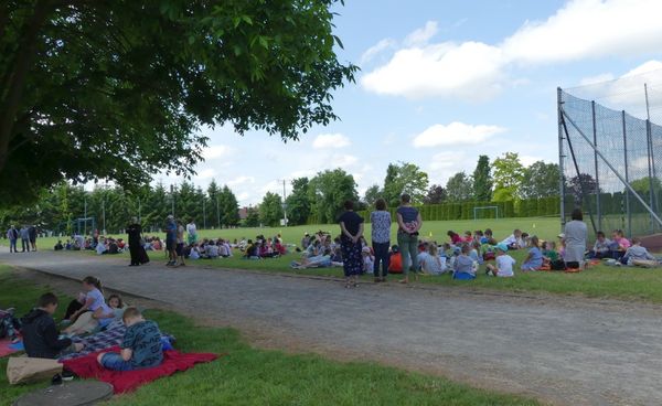 Uczniowie czytający książki na boisku szkolnym.