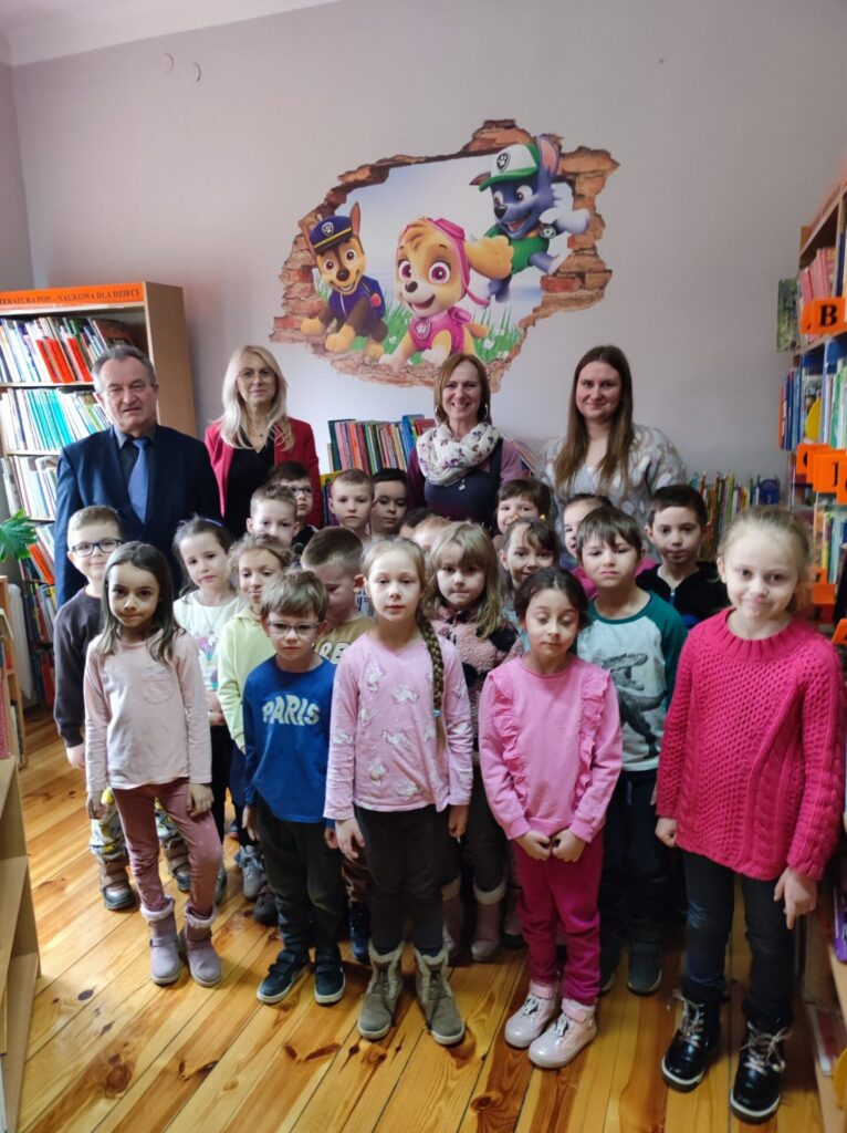 Zdjęcie grupowe: dziewiętnaścioro przedszkolaków wraz z opiekunem, Wójt Gminy, Dyrektor biblioteki oraz bibliotekarka.