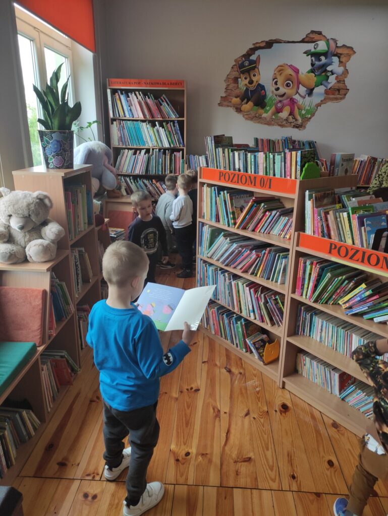 Czworo dzieci w wypożyczalni dla dzieci w bibliotece.
