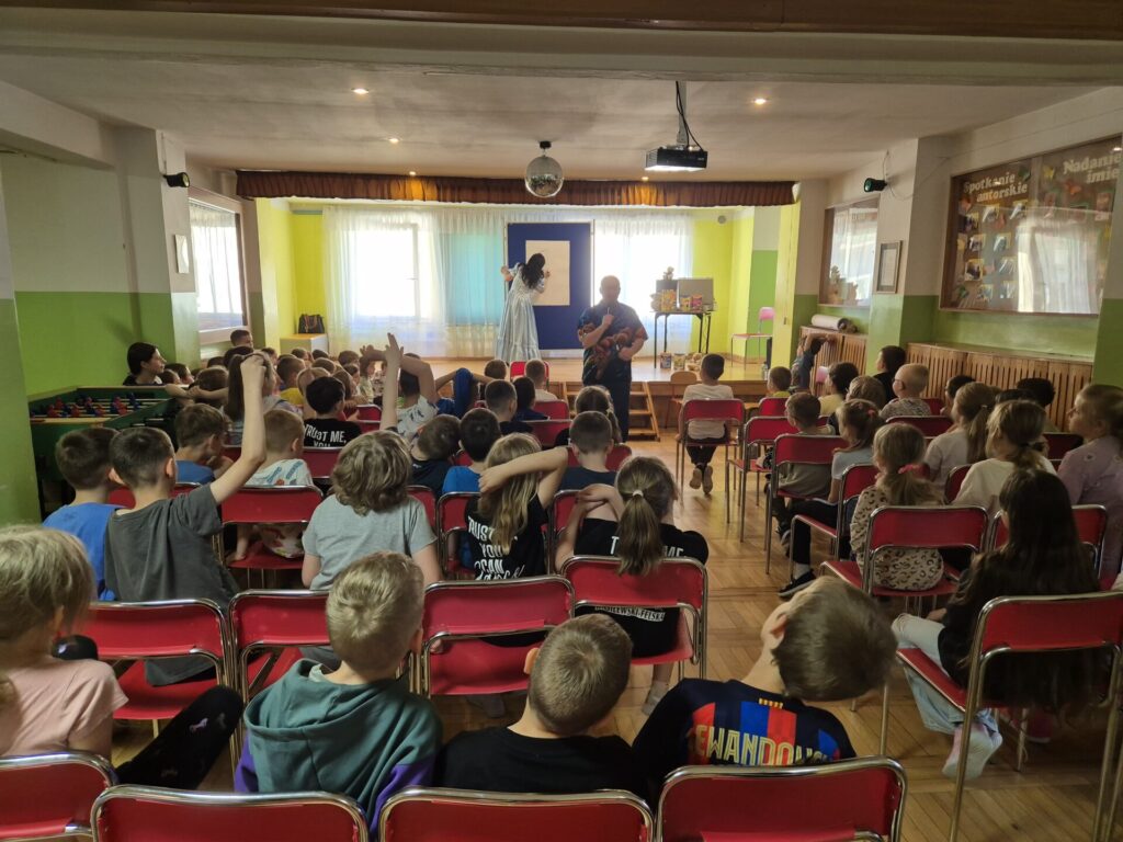 Grupa dzieci na spotkaniu autorskim z Edytą i Robertem Zarębskimi w Szkole Podstawowej w Bogucinie.