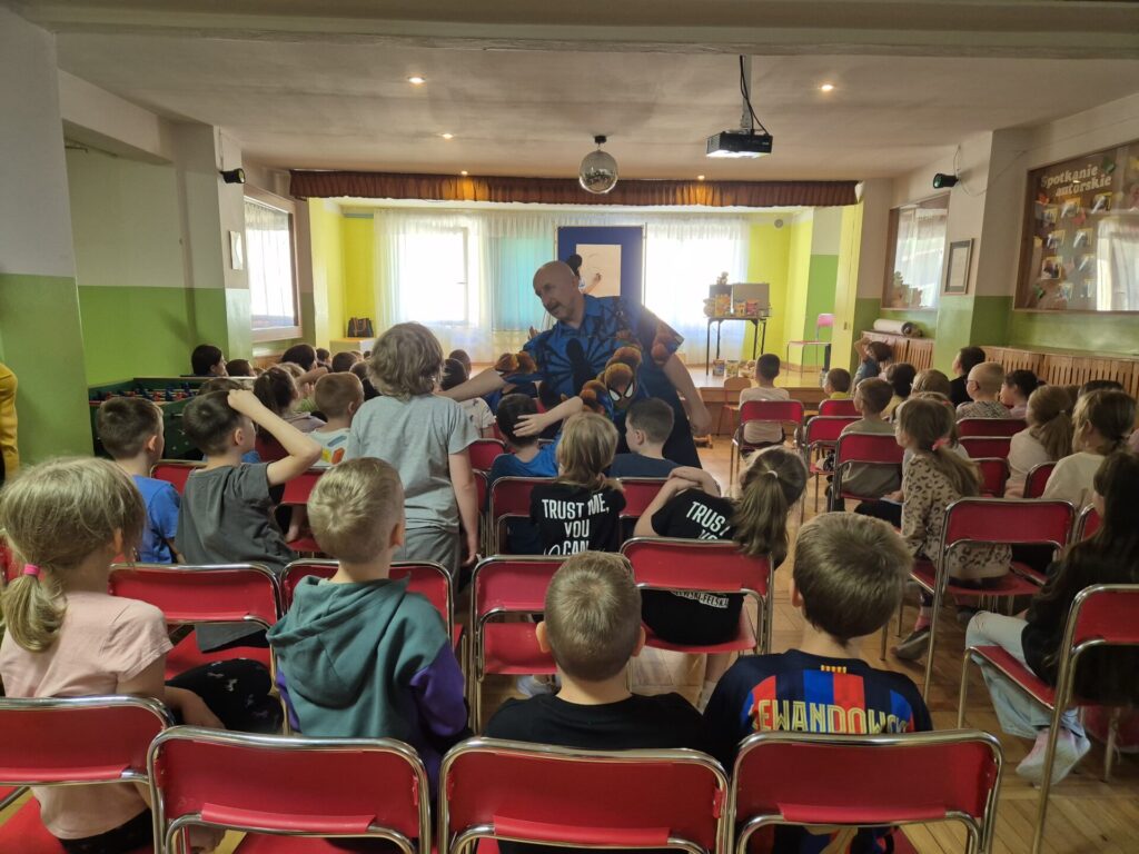 Grupa dzieci na spotkaniu autorskim z Edytą i Robertem Zarębskimi w Szkole Podstawowej w Bogucinie.