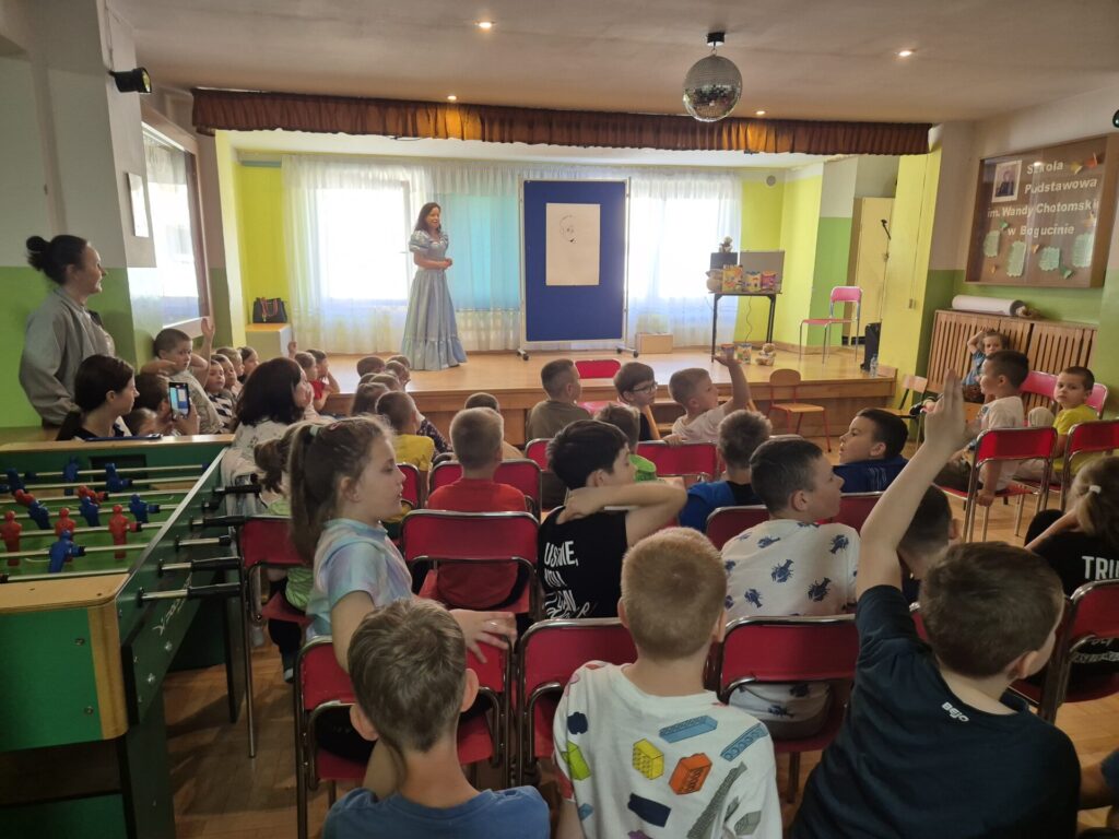 Grupa dzieci na spotkaniu autorskim z Edytą i Robertem Zarębskimi w Szkole Podstawowej w Bogucinie.