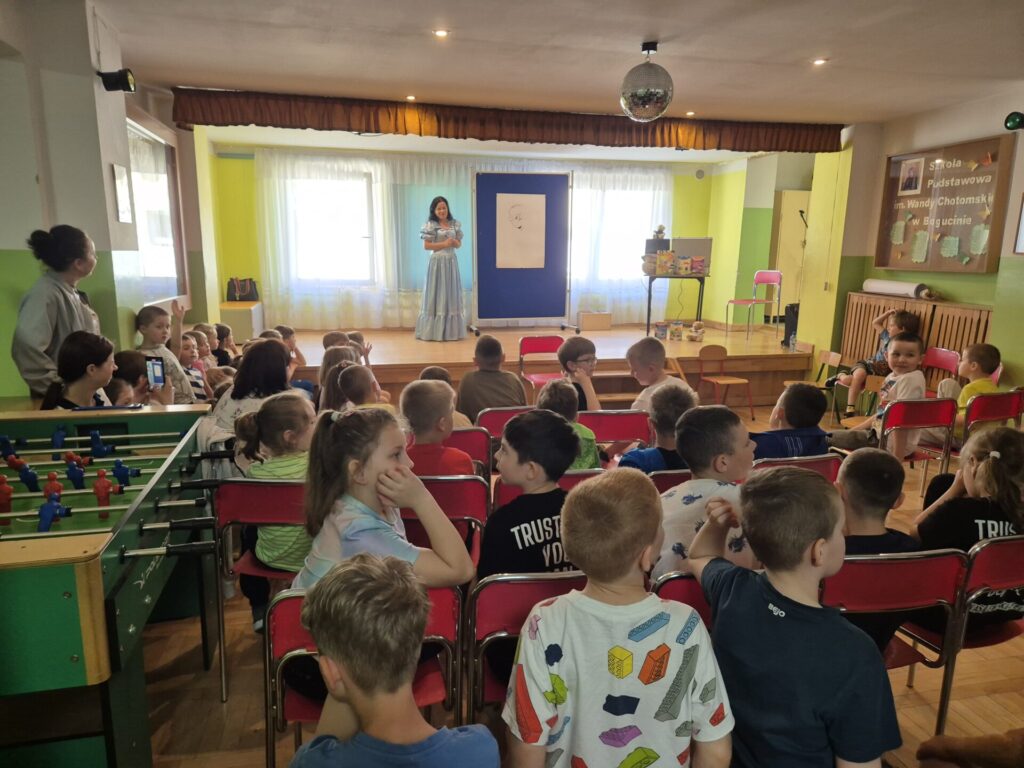Grupa dzieci na spotkaniu autorskim z Edytą i Robertem Zarębskimi w Szkole Podstawowej w Bogucinie.
