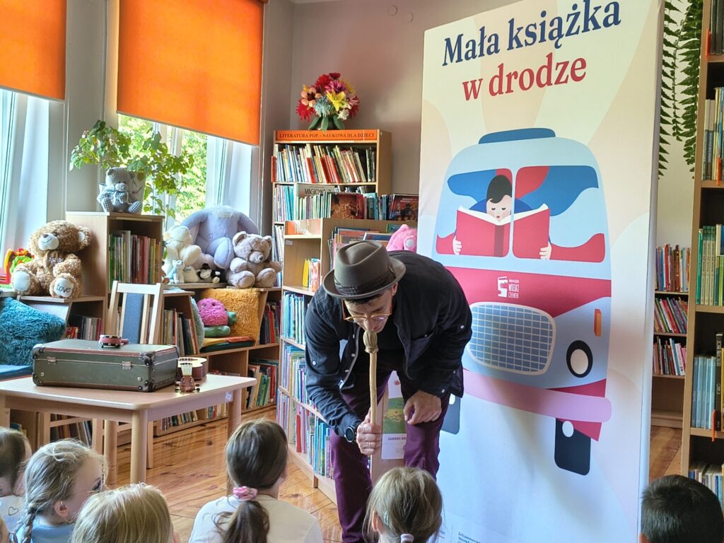 Piętnaścioro dzieci uczestniczących w warsztatach czytelniczych z animatorem Krystianem Truchalskim w GBP w Garbowie.