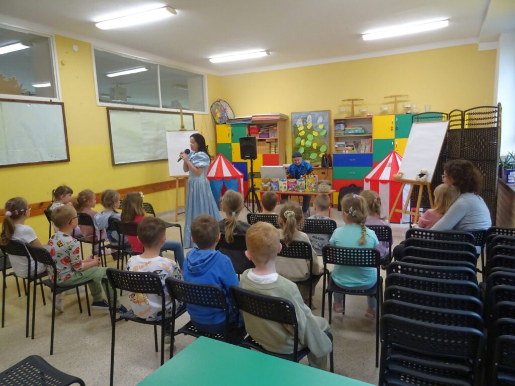 Grupa przedszkolaków w sali szkolnej uczestniczących w spotkaniu autorskim z Edytą i Robertem Zarębskimi.