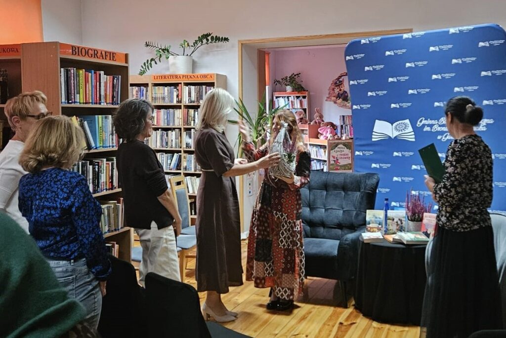 cztery czytelniczki i dyrektor wręczająca kwiat pisarce