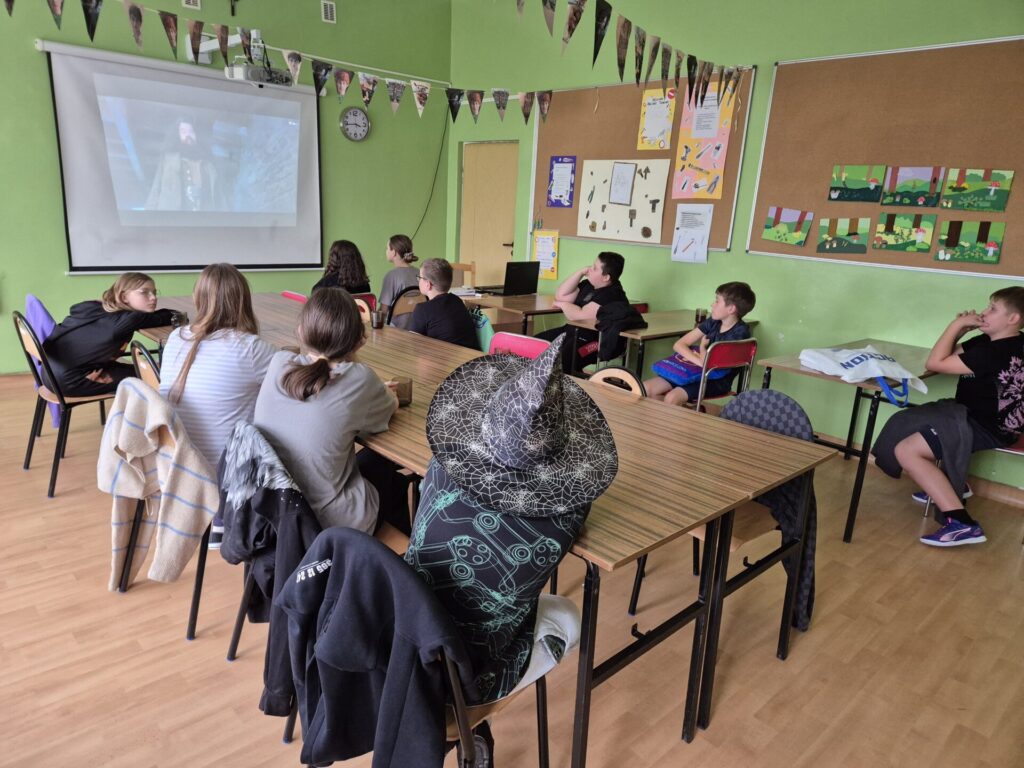 dziesięcioro dzieci wraz z opiekunem oglądających film