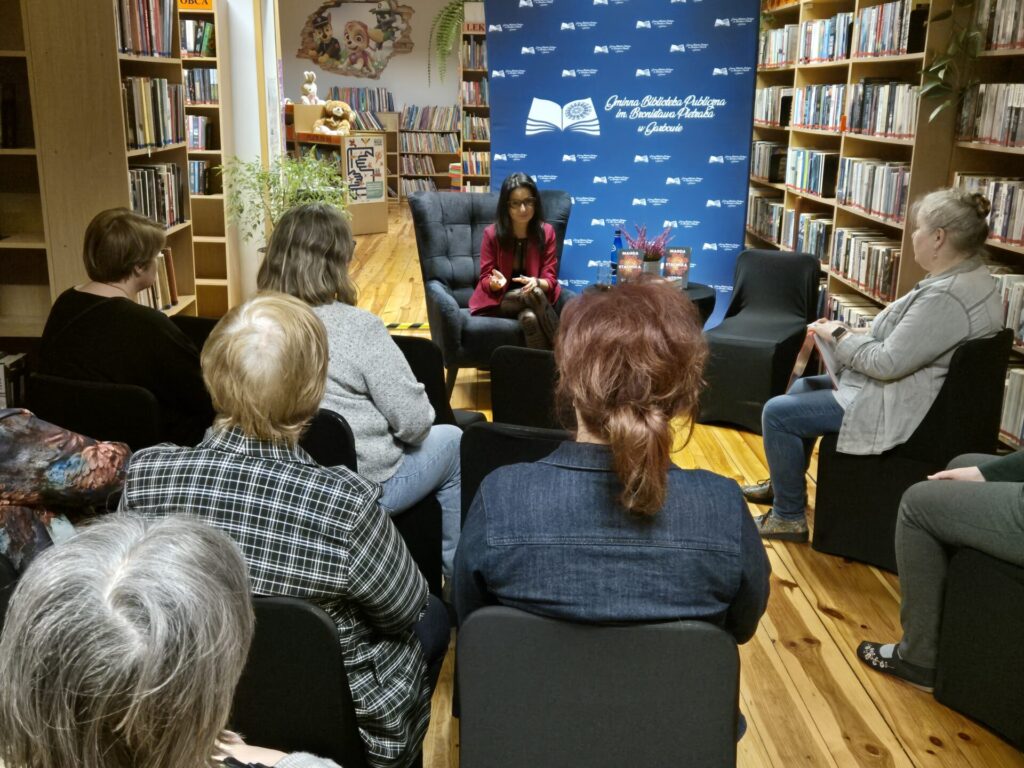 Czytelnicy uczestniczący w spotkaniu autorskim z Magdą Stachulą w bibliotece.