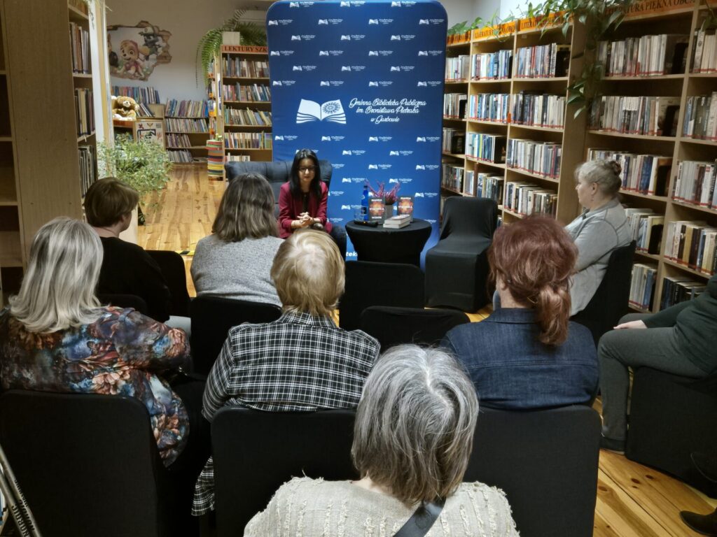 Czytelnicy uczestniczący w spotkaniu autorskim z Magdą Stachulą w bibliotece.