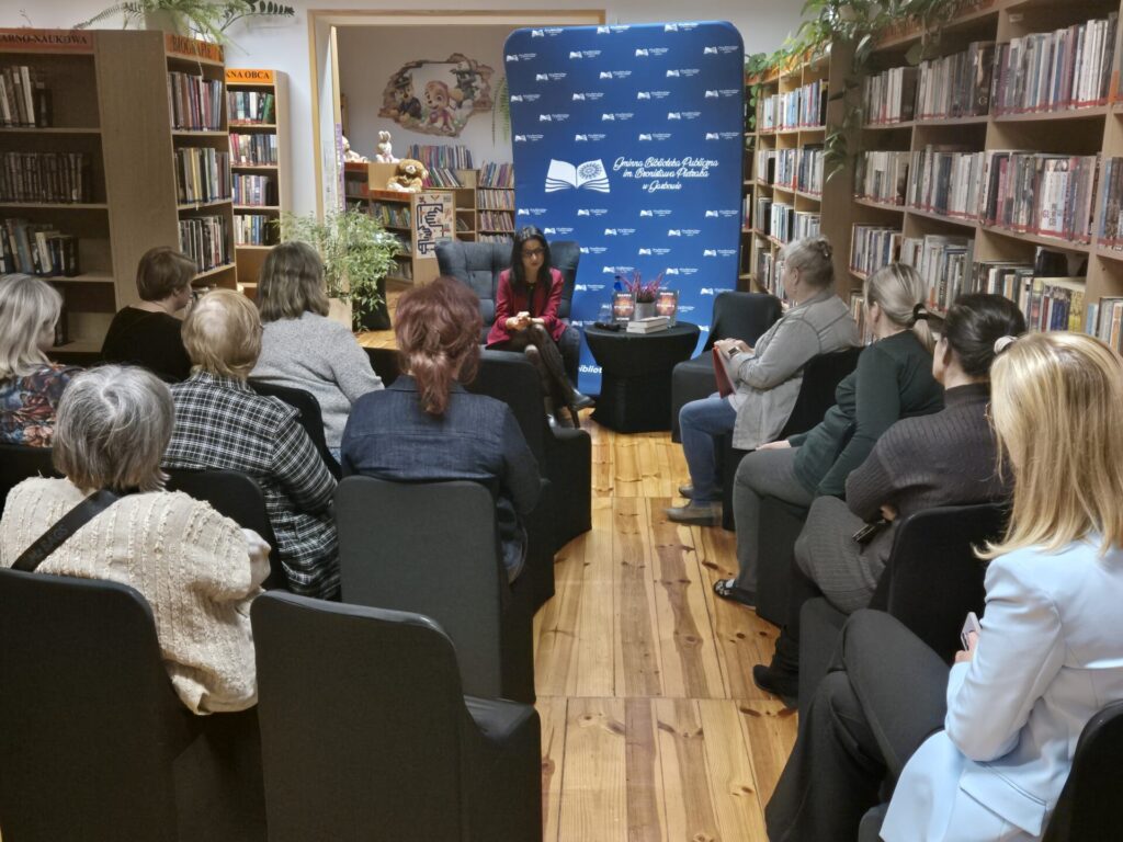 Czytelnicy uczestniczący w spotkaniu autorskim z Magdą Stachulą w bibliotece.