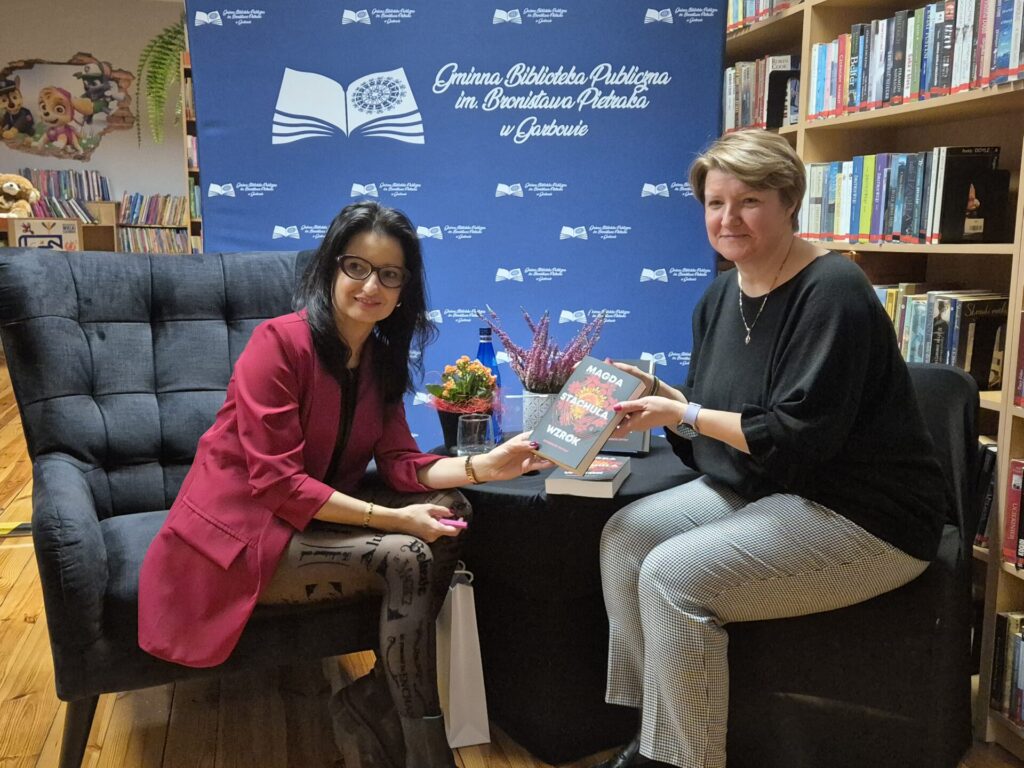 Magda Stachula przekazuje książkę czytelniczce.