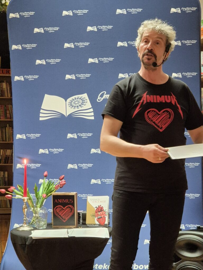 Piotr Pilarski podczas spotkania autorskiego w bibliotece.