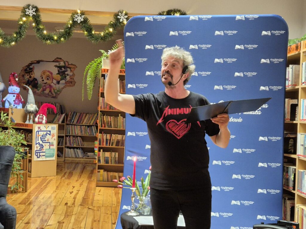 Piotr Pilarski podczas spotkania autorskiego w bibliotece.