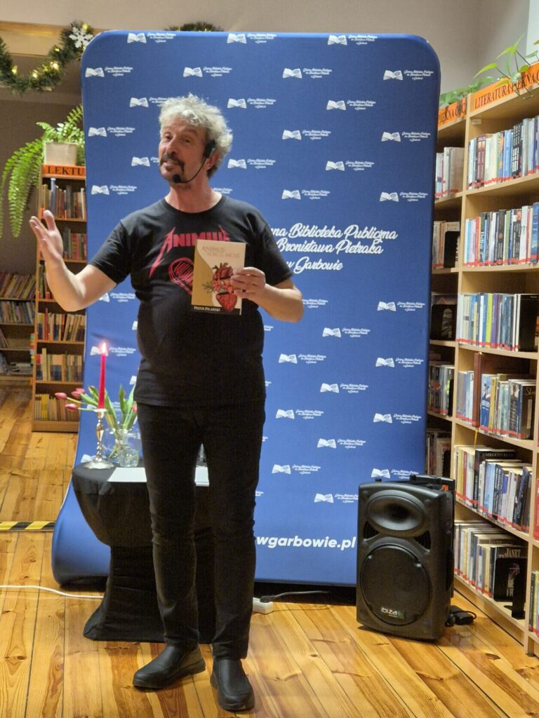 Piotr Pilarski podczas spotkania autorskiego w bibliotece.