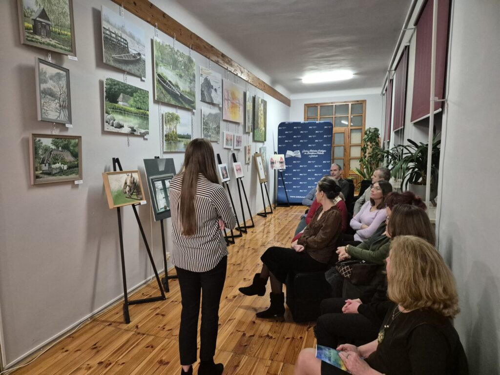 Kilkanaście osób na wernisażu malarstwa.
