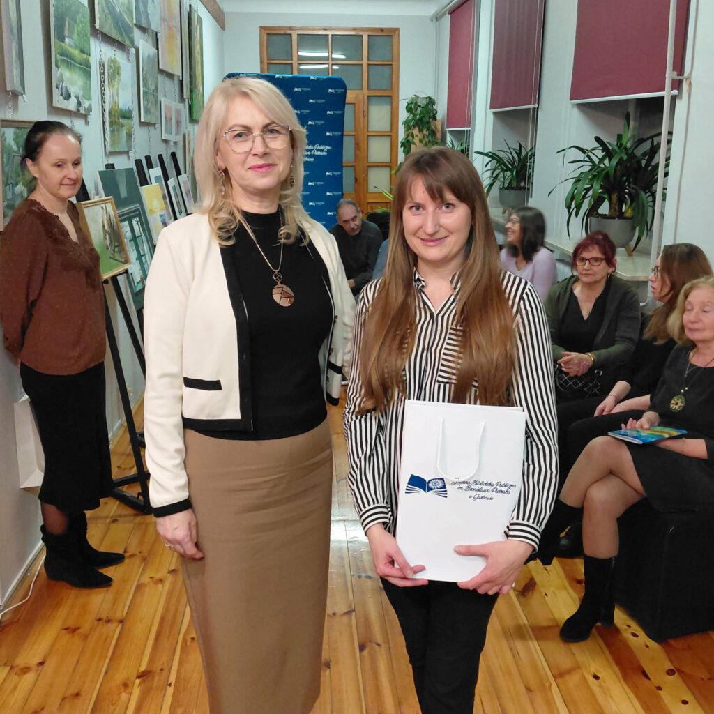 Kilkanaście osób na wernisażu malarstwa.