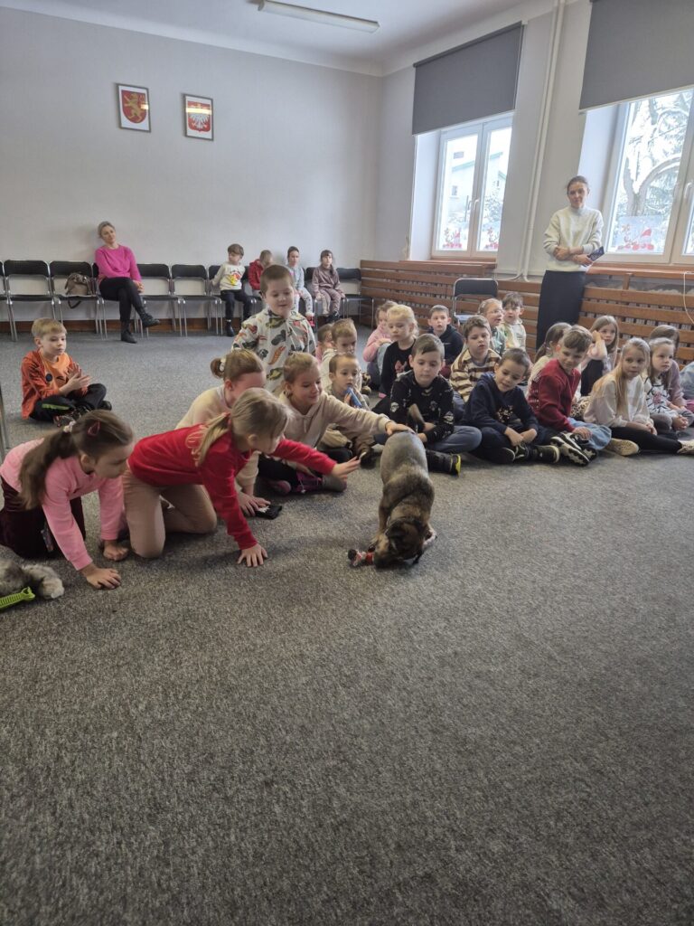 Dzieci na spotkaniu autorskim z Martą Maj głaszczą Precla