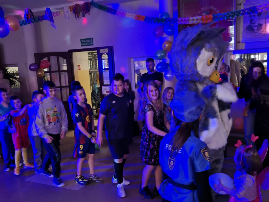 Dzieci tańczące na balu karnawałowym z sową