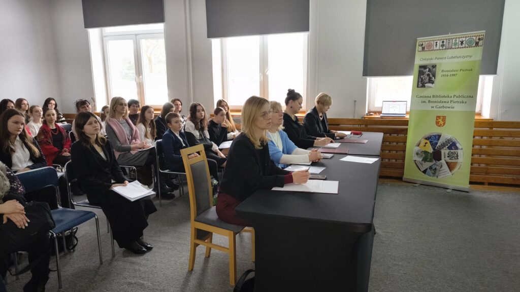 Jury podczas przesłuchiwania uczestników konkursu. W tle publiczność uczestnicy i opiekunowie.