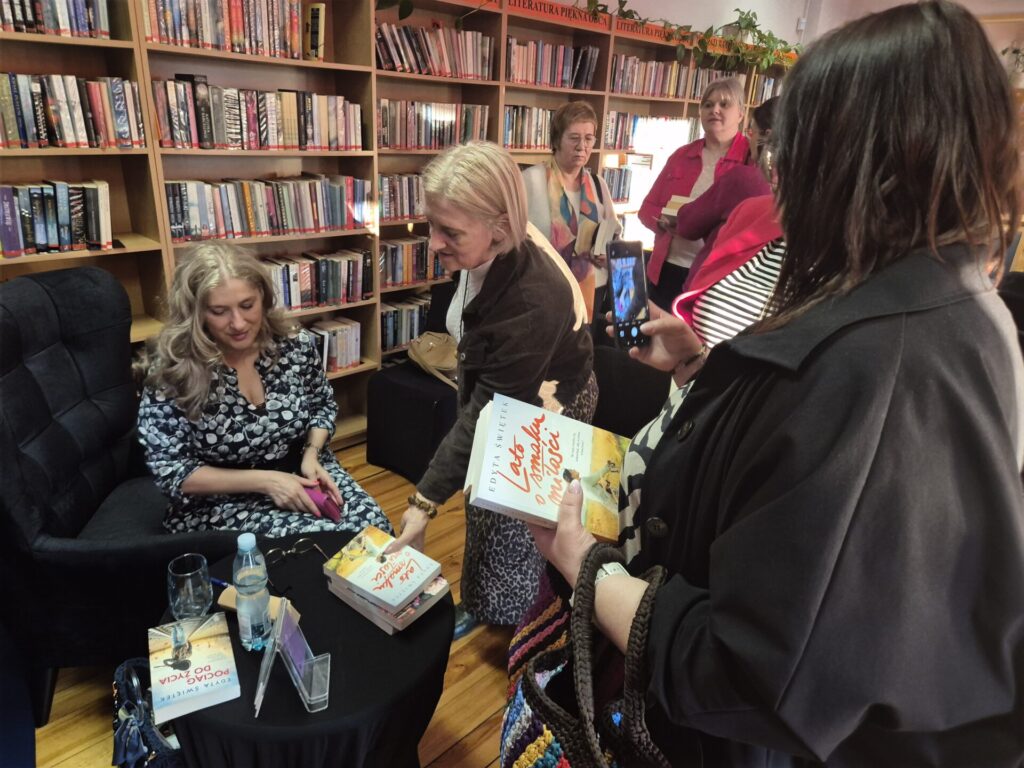 Pisarka Edyta Świętek podpisująca książki.