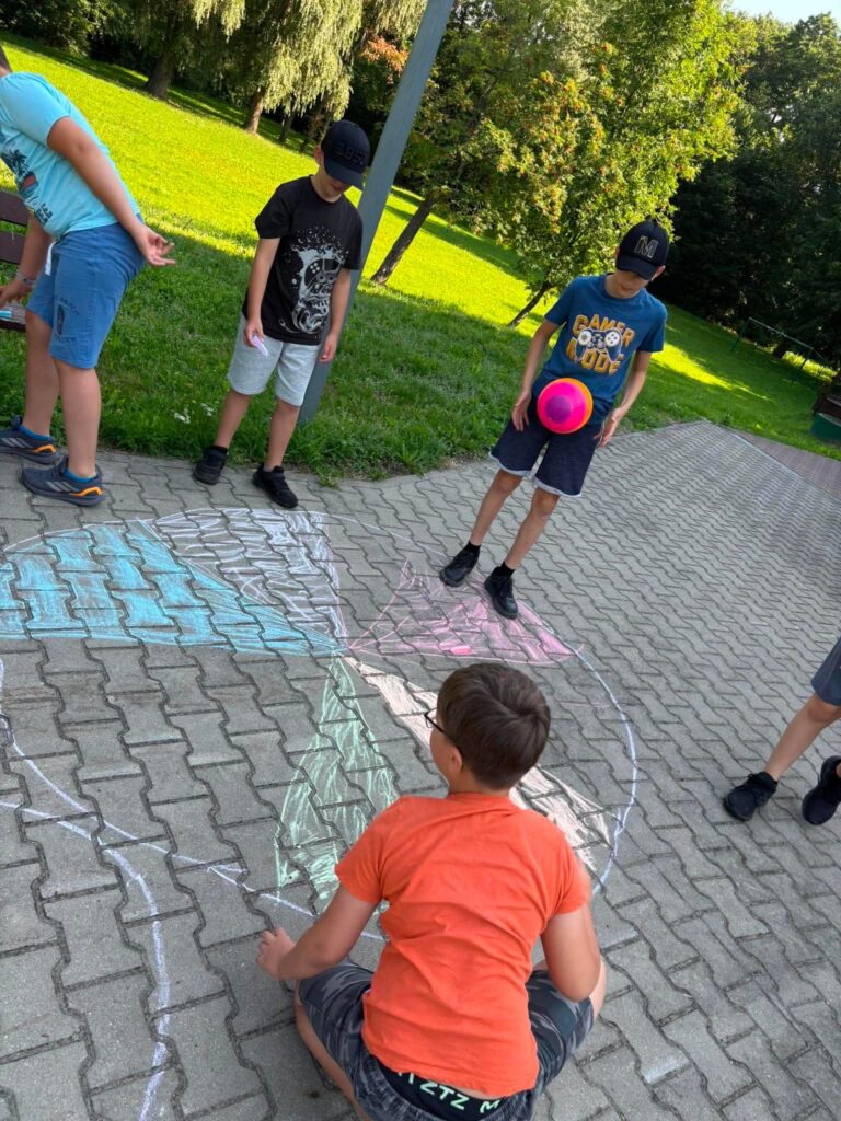 czterech chłopców malujących kredą na kostce
