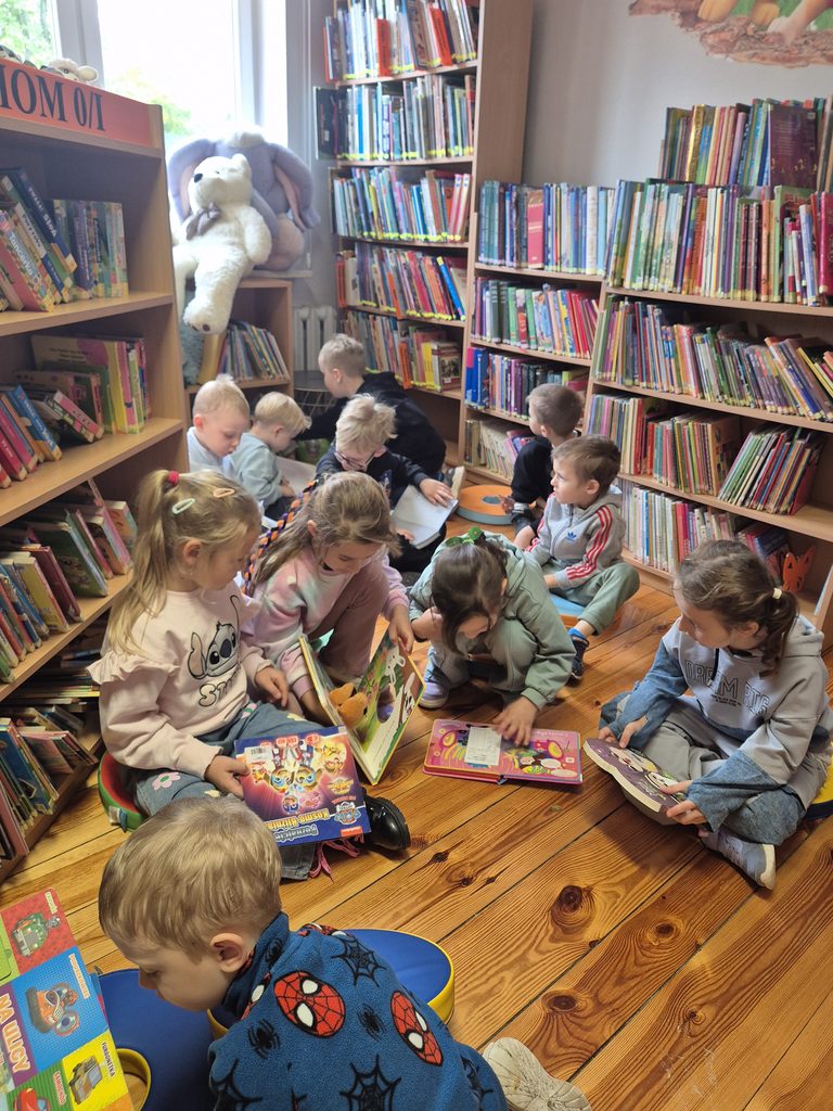 przedszkolaki oglądają książki w bibliotece