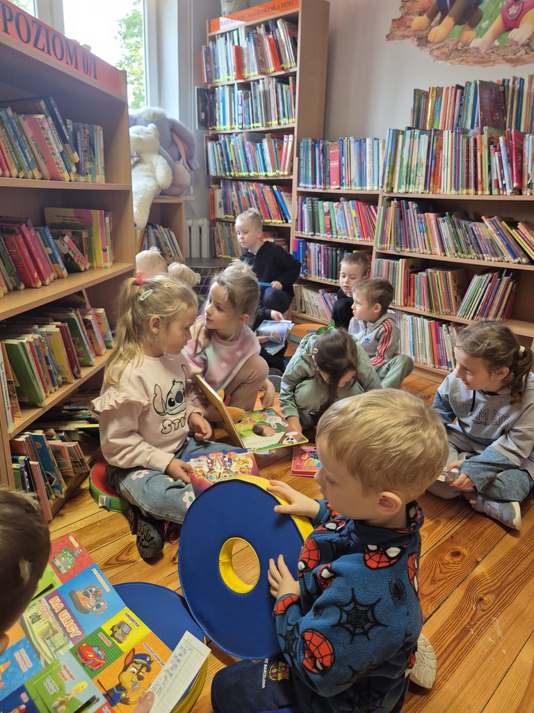 przedszkolaki oglądają książki w bibliotece